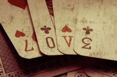 several playing cards are stacked on top of each other with the word love spelled in black and white