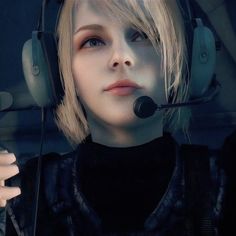 a woman with headphones on her ears and wearing a headset is looking into the distance