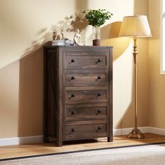 a wooden chest of drawers sitting in a room next to a lamp and a window