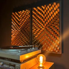 a record player sitting on top of a wooden table next to a wall mounted sound board