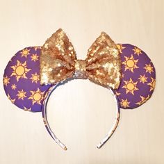 a purple and gold minnie mouse ears with sun designs