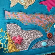 a close up of a piece of fabric with buttons and fish on it's side