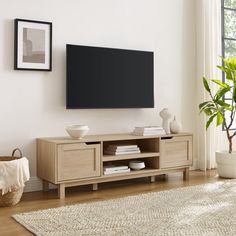 a flat screen tv mounted to the side of a wooden entertainment center in a living room