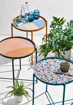 three tables with plants and drinks on them