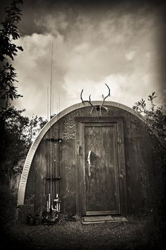 an old outhouse with antlers on the roof and door is shown in black and white