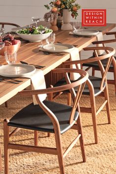 a wooden table with chairs and plates on it