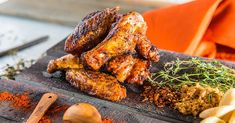 chicken wings with spices and seasoning on a cutting board next to other food items