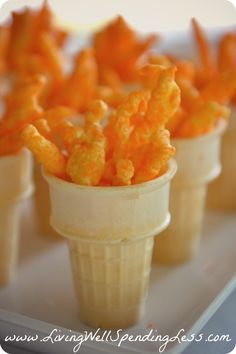 small cups filled with cheetos sitting on top of a table