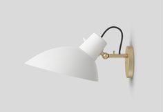 a white wall light with a black cord attached to the back of it and an angled arm