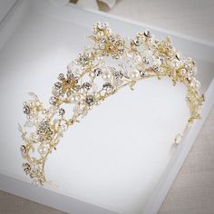 A romantic tiara design that can complete the most sophisticated of bridal looks. Intricately faceted cubic zirconia work their way across the band in a leaf and flower pattern, while iridescent pearls create a stunning effect.Cast in lightweight alloy and 14K yellow gold plated for a flawless finish, the headband measures 2.25" (approx. 6cm) at the highest point and 6" in diameter (approx. 15cm). Two small loops at each end make it easy to attach to your hair with bobby pins. Its incredible spa Tiara Design, Gold Hair Accessories Wedding, Gold Hair Accessories, Iridescent Pearl, Wedding Tiara, Colored Wedding Dresses, Bridal Tiara, Gold Pearl, Wedding Hair Accessories