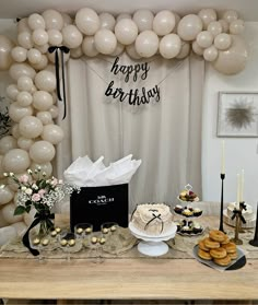 a table topped with lots of desserts and balloons