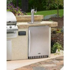 a stainless steel outdoor kitchen with an outside sink and grill in the back yard area