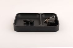 an earbud tray with two separate compartments for the same device, on a white surface