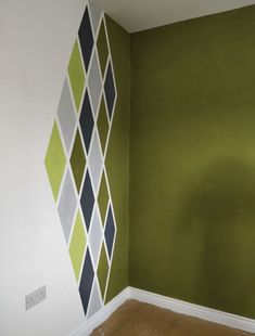 an empty room with green walls and white trim on the wall, painted in different colors