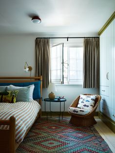 a bed room with a neatly made bed and a chair