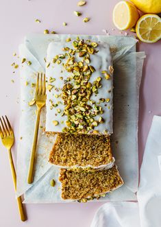 three slices of cake sitting on top of each other next to forks and lemons