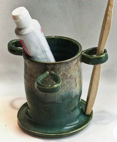 a toothbrush holder with two toothpaste tubes and a tube in the cup