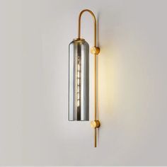 a light that is on the wall next to a white wall with a metal tube