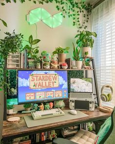 a computer desk with plants on top of it and a keyboard in front of the monitor