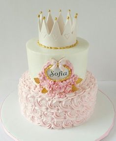 a white cake with pink flowers and a crown on top that says sofaa