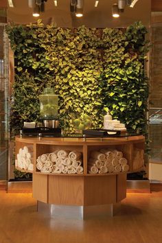 a bathroom with a green wall behind the counter and towels stacked on top of it