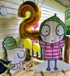 some paper cutouts and balloons on a porch