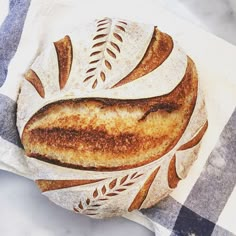 a loaf of bread sitting on top of a blue and white checkered table cloth