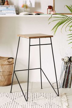 a small wooden stool sitting on top of a white floor