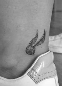 a small tattoo on the ankle of a woman's foot with a ball of yarn