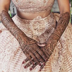 a woman with henna tattoos on her hands and chest is posing for the camera