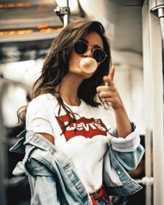 a woman blowing bubbles while wearing a white t - shirt with the word love on it