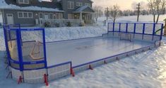 an ice skating rink in the middle of a snow - covered yard with two children's play areas