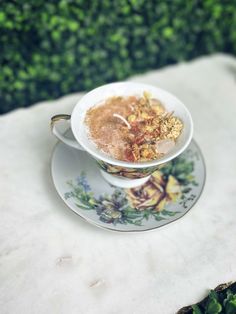 a bowl of cereal sitting on top of a saucer next to a green bush