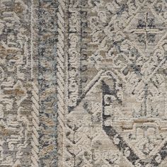 an old rug with many different patterns and colors on the carpet, including blue, gray,