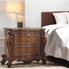 a night stand with two drawers and a lamp next to it on a carpeted floor