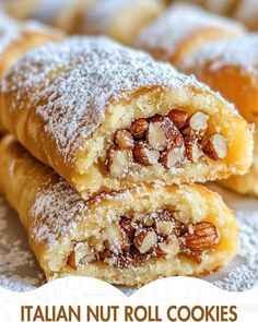 two pieces of bread with nuts and powdered sugar on top sitting on a plate