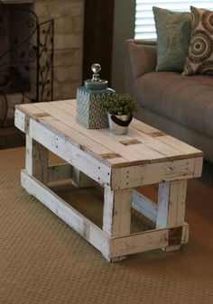 a coffee table made out of pallet wood with a potted plant on top