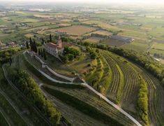 an aerial view of a small village surrounded by trees and fields with train tracks running through it