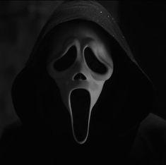 a person wearing a mask with their mouth wide open and tongue out in the dark