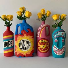 three vases with yellow roses in them are painted to look like gas cans and flowers