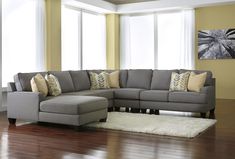 a living room with a sectional couch and pillows