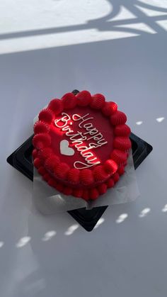 a red cake sitting on top of a black plate