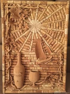 a wall sculpture made out of wine corks with a sailboat on the water