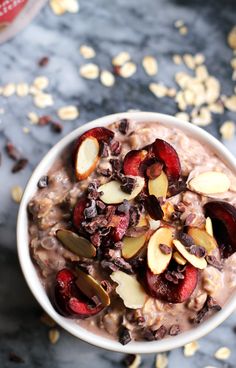 a bowl filled with oatmeal topped with fruit and nuts