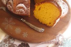 a bundt cake on a wooden platter with a slice cut out