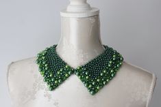 Handmade collar necklace with round pearls in emerald green / dark green color, in different size and clear green beads and opalescent beads. Ribbon tied on the back - adjustable for every neck size. Pointed shape. Peter pan collar type. Every single bead is handsewn.  Collar gives a chic touch to simple dresses and blouses.  One size. Handmade item. Wonderful gift for women or female friends. Please check out other items in my shop. You can find there collars in different shapes, colors and materials. Great to wear everyday and also for special occasions. Female Tie, Necklace With Pearls, Dark Green Color, Single Bead, Beaded Collar, Green Beads, Female Friends, Ribbon Tie, Green Dark