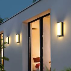 an exterior view of a modern home with lights on the outside and bedroom in the background