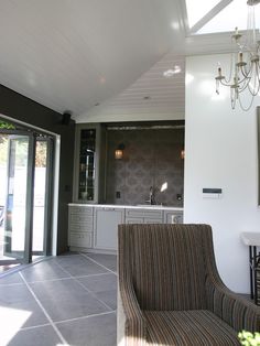 a living room filled with furniture and a chandelier hanging from the side of it