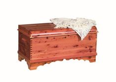 a wooden chest with a blanket on top