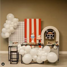 a table with white balloons and an american flag on the wall next to some tables